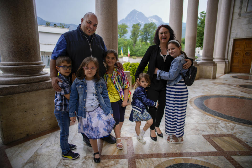 Pietro di Bartolomeo, left, poses with his wife Roberta Cameli and children Beatrice, 10, Ester, 9, Luca, 7, Carmen, 5, and Noemi, 3, at the St. Gabriele dell'Addolorata sanctuary in Isola del Gran Sasso near Teramo in central Italy Saturday, June 3, 2023. Pietro di Bartolomeo was bullied when he was a teen because of his family's strong faith, and he "saw God as a loser." Now a 45-year-old father of five, he runs a Bible group for a dozen teens in Teramo, trying to keep them connected to their faith after confirmation. (AP Photo/Domenico Stinellis)