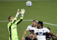 Seattle Sounders goalkeeper Stefan Frei, left, grabs the ball away from Vancouver Whitecaps defender Derek Cornelius, right, during the second half of an MLS soccer match in Portland, Ore., Tuesday, Oct. 27, 2020. Seattle won 2-0. (AP Photo/Steve Dykes)