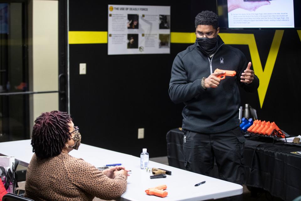 A firearms instructor leads a gun safety training class.