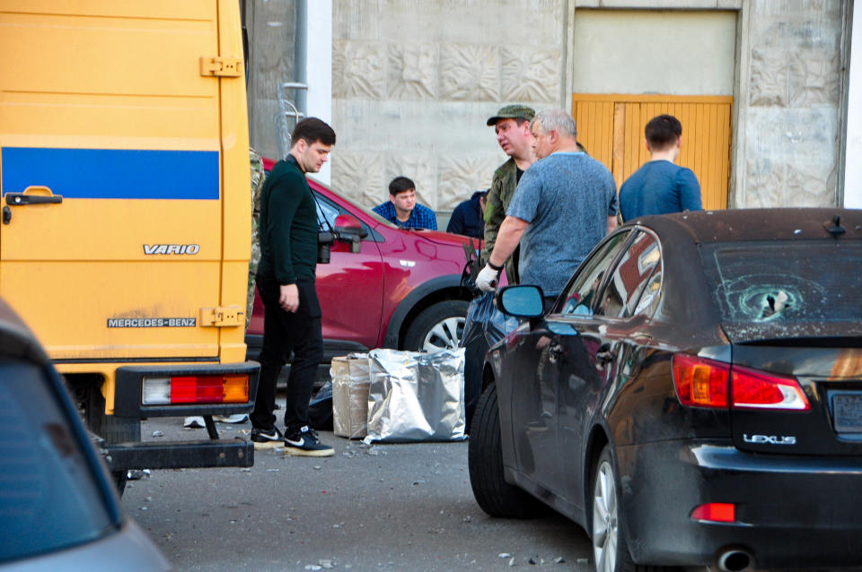 Investigators work at the site of the place where the downed Ukrainian drone fell in Krasnogorsk, just outside Moscow, Russia, Tuesday, Aug. 22, 2023. Andrei Vorobyov, the governor of the Moscow region, said that two Ukrainian drones were shot down by air defenses on western outskirts of the Russian capital early Tuesday. (Moscow News Agency via AP)