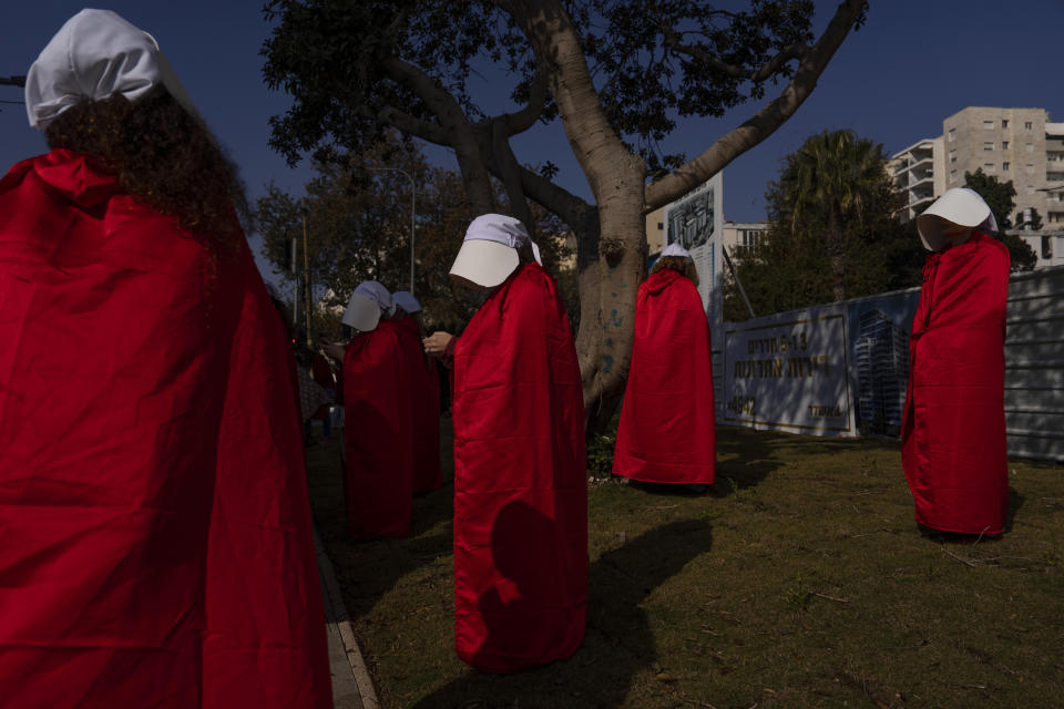 Protesters supporting women's rights dressed as characters from The Handmaid's Tale TV series attend a protest against plans by Prime Minister Benjamin Netanyahu's new government to overhaul the judicial system in Tel Aviv, Monday, Feb. 20, 2023. Israel's government on Monday was pressing ahead with a contentious plan to overhaul the country's legal system, despite an unprecedented uproar that has included mass protests, warnings from military and business leaders and calls for restraint by the United States. (AP Photo/Oded Balilty)