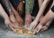 Pro-democracy student leaders install a plaque declaring "This country belongs to the people" at the Sanam Luang field during a protest in Bangkok, Thailand, Sunday, Sept. 20, 2020. Anti-government demonstrators occupying a historic field in the Thai capital on Sunday installed a plaque symbolizing the country's transition to democracy to replace the original one that was mysteriously ripped and stolen three years ago, as they vowed to press on with calls for new elections and reform of the monarchy. (AP Photo/Sakchai Lalit)