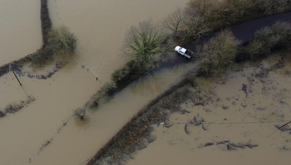 A car stops before a flooded part of the road by the Ouse river in Barcombe Mills, East Sussex, England, Friday, Jan. 5, 2024. (Gareth Fuller/PA via AP)