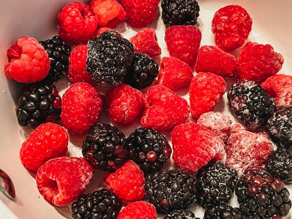 raspberries and blackberries in a pot with some sugar