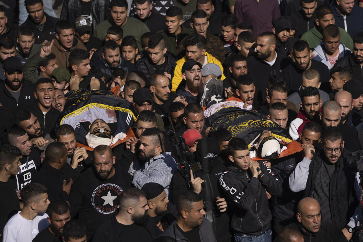 Palestinian mourners carry the bodies of Naeem Jamal Zubaidi, 27, right and Mohammad Ayman Saadi, 26, covered with flags of the Islamic Jihad Movement, during their funeral in the West Bank city of Jenin, Thursday, Dec. 1, 2022. Israeli forces killed Zubaidi and Saadi during an arrest raid Thursday in the occupied West Bank, according to the Israeli military and the Islamic Jihad militant group, the latest bloodshed in months of violence between the sides. (AP Photo/Nasser Nasser)