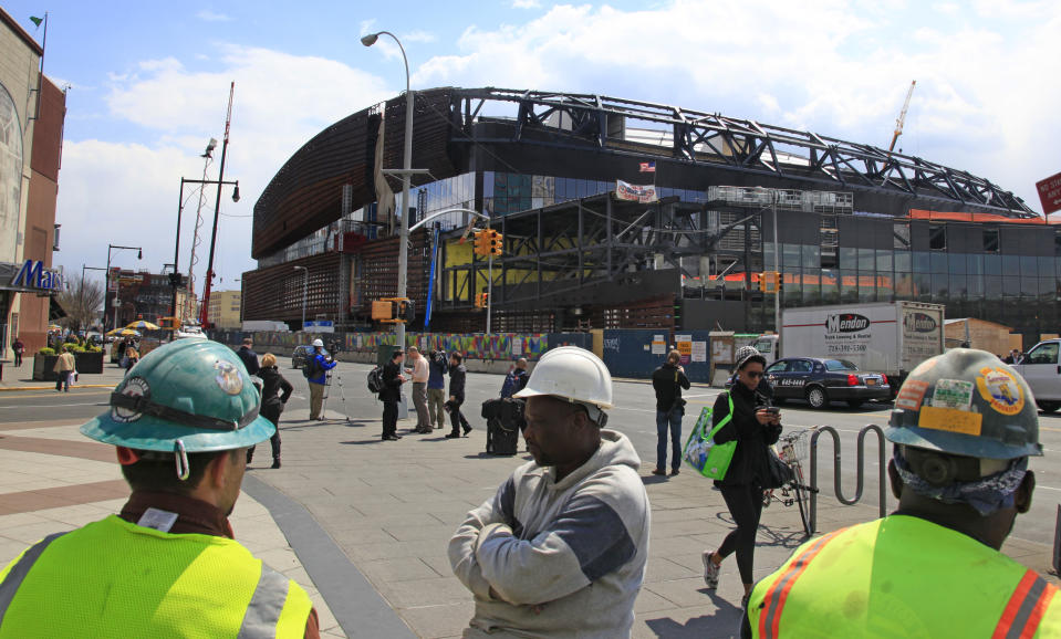 Construction workers take a lunchtime break from work at the Barclays Center arena on Tuesday, April 10, 2012 in the Brooklyn borough of New York. Mikhail Prokhorov, the Russian billionaire owner of the New Jersey Nets basketball team, surveyed the ongoing construction for the Nets new home and said he's "very committed" to bringing an NBA title to Brooklyn. (AP Photo/Bebeto Matthews)