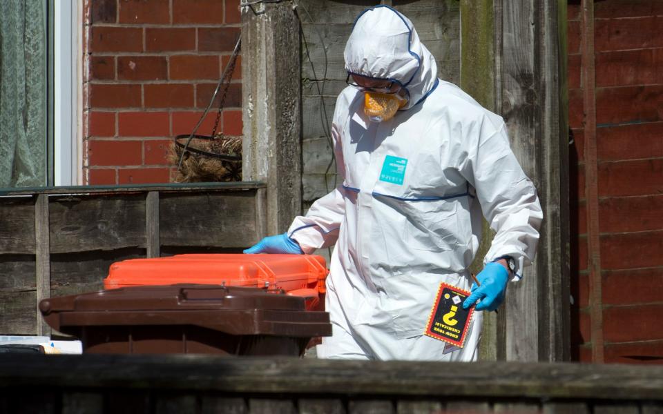 One forensic officer carries a "Know Your Chemicals" book as he leaves the property  - Credit: JULIAN SIMMONDS
