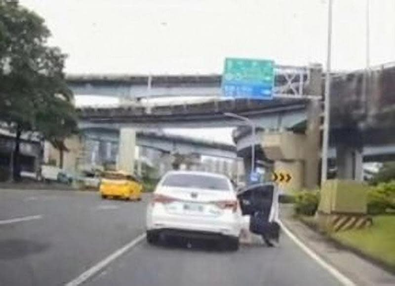 汪姓女子從行駛中車輛跳車掉落地面，嚇壞後方汽車駕駛。（翻攝畫面）