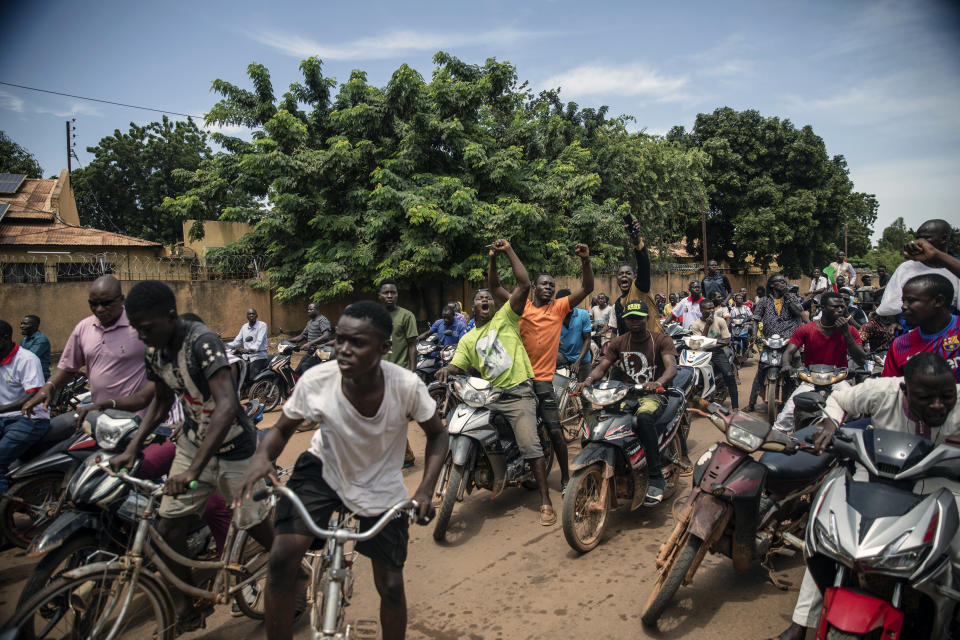 Young men chant slogans against the power of Lieutenant-Colonel Damiba, against France and pro-Russia, in Ouagadougou, Burkina Faso, Friday Sept. 30, 2022. Residents say gunfire rang out early in the morning and the state broadcaster has gone off the air, fueling fears that another coup is underway. The developments Friday come just after coup leader-turned-president, Lt. Col. Paul Henri Sandaogo Damiba, returned from a trip to the U.N. General Assembly. (AP Photo/Sophie Garcia)