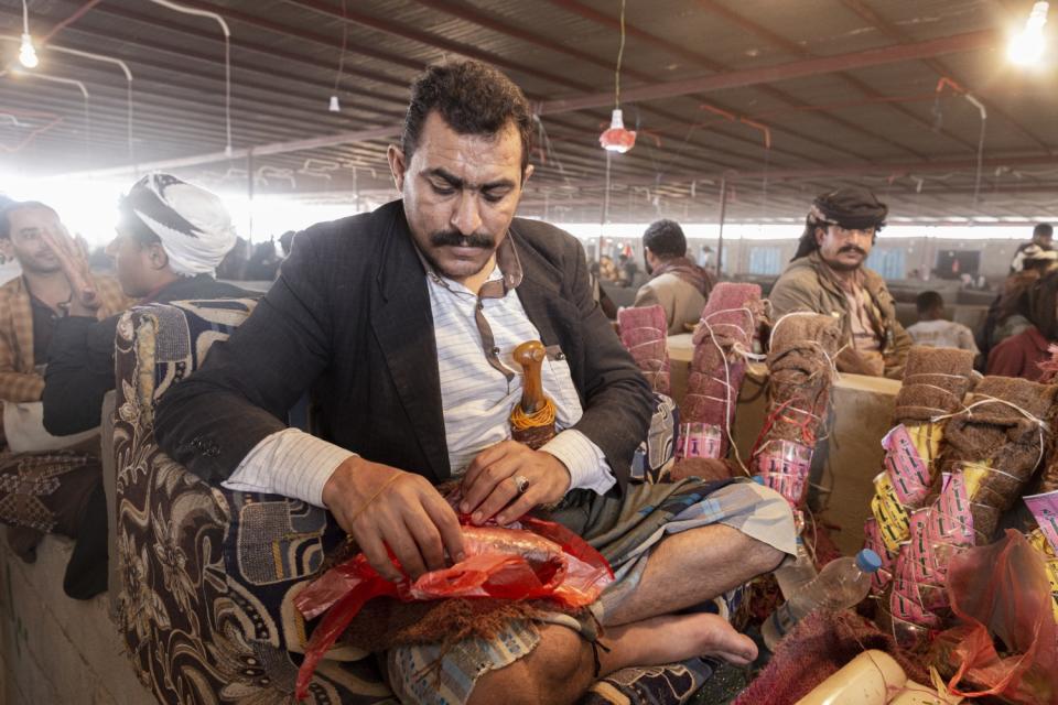 A seller displays his product at the khat market in Ataq, Yemen.