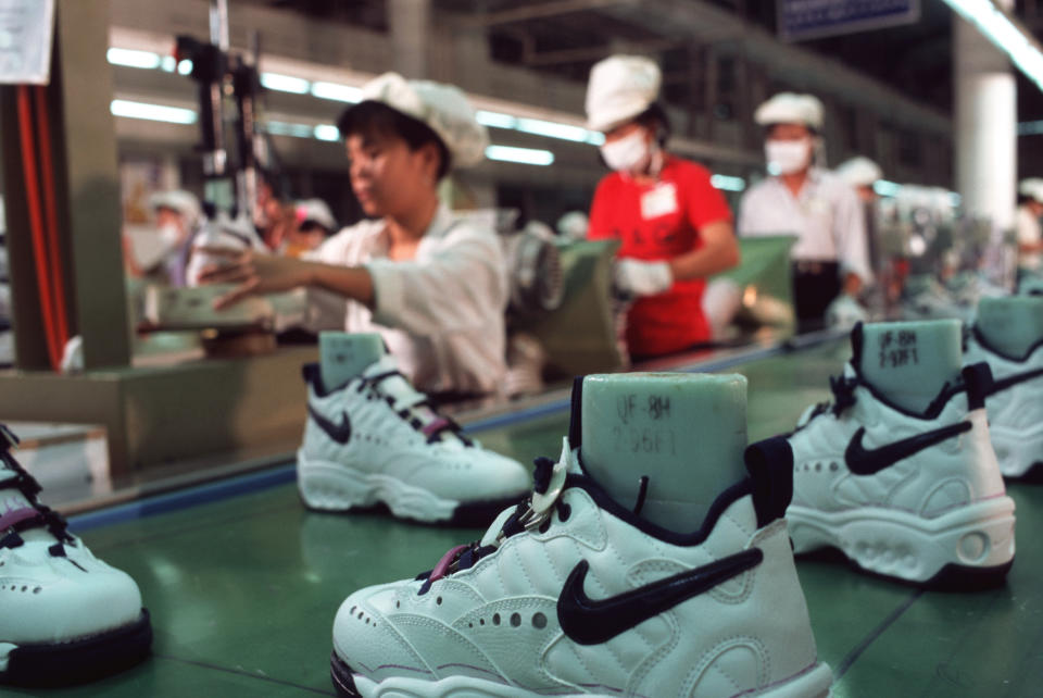 HO CHI MINH CITY, VIETNAM - 1997/08/01: Workers in a Nike factory near Ho Chi Minh City work at a production line conveyor belt, putting together Nike sports shoes.. (Photo by Peter Charlesworth/LightRocket via Getty Images)