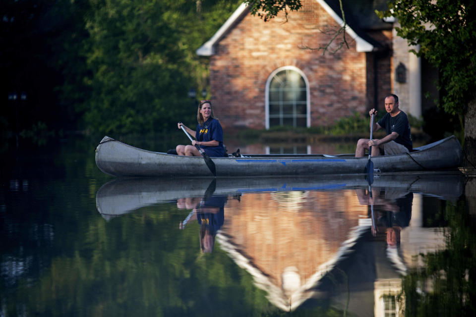 Danny and Alys Messenger paddle away from their flooded home after reviewing the damage in Prairieville, La., on Tuesday. (Photo: Max Becherer/AP)