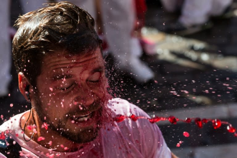 A journalist is sprayed with wine by revellers at the start of the San Fermin Festival in Pamplona, northern Spain, on July 6, 2016