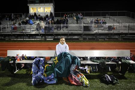 Fifteen year-old Sarah Steenhuysen (C) watches her high school soccer teammates play a game against Bishop Feehan in Attleboro, Massachusetts October 25, 2013. REUTERS/Brian Snyder