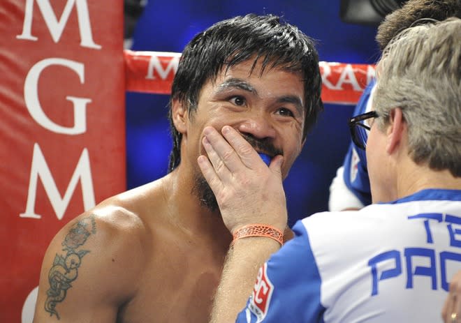 Trainer Freddie Roach (R) confers between rounds with Manny Pacquiao (L) of the Philippines during their WBO welterweight title match against Timothy Bradley of the US at the MGM Grand Arena on June 9, 2012 in Las Vegas, Nevada. In what is being viewed as a highly controversial and unpopular outcome, unbeaten Bradley ended Pacquiao's long unbeaten run with a split decision victory over the Filipino ring icon. AFP PHOTO / JOE KLAMARJOE KLAMAR/AFP/GettyImages