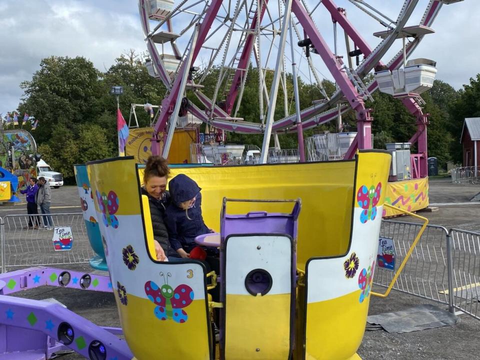 Talitha LeBlanc and her daughter Amara sit in the teacup ride at the Carp Fair on Thursday, during an hour set aside for kids and adults with disabilities.  (Sannah Choi/CBC News - image credit)