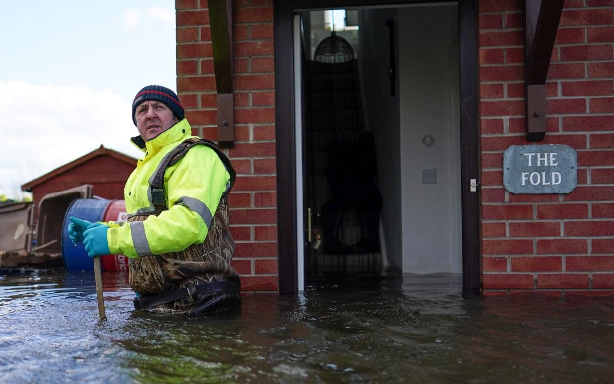 Steve Lamb stands by the door of his father's home as he prepares to enter as flooding affects homes and businesses after the River Aire bursts its banks on March 01, 2020 in East Cowick, England - Getty