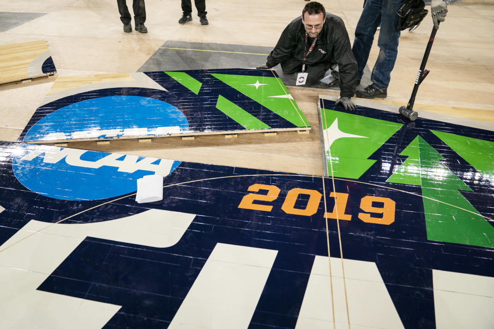 U.S. Bank Stadium operations worker Michael Stauffacher helps install the court for the NCAA Final Four college basketball tournament in Minneapolis, Friday, March 29, 2019.  (Leila Navadi/Star Tribune via AP)