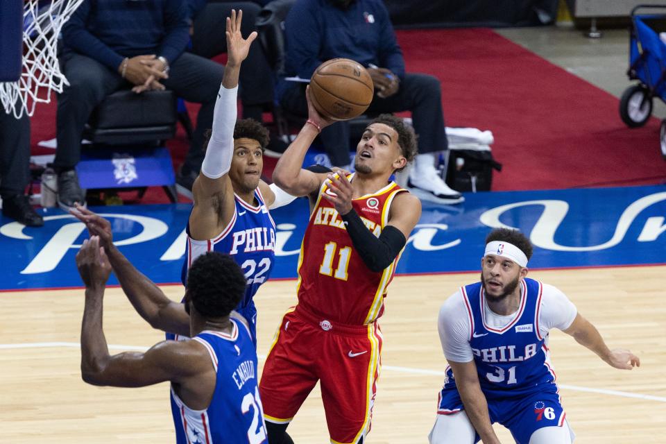 Atlanta Hawks guard Trae Young (11) drives to lane to score against Philadelphia 76ers center Joel Embiid (21), guard Seth Curry (31) and guard Matisse Thybulle (22) during the fourth quarter of Game 5.
