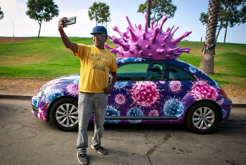 EL SEGUNDO, CA - JUNE 27: Aaron Sanderlin of Inglewood takes a selfie by a Volkswagen Covid-19 car on Sunday, June 27, 2021 in El Segundo, CA. (Jason Armond / Los Angeles Times)