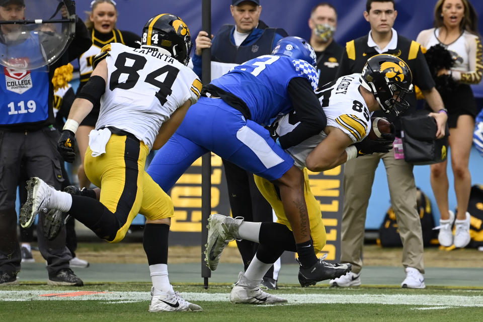 Iowa tight end Luke Lachey (85) scores a touchdown after catching pass as Kentucky linebacker J.J. Weaver (13) tries to knock him out of bounds in the first half of the Music City Bowl NCAA college football game against Kentucky Saturday, Dec. 31, 2022, in Nashville, Tenn. (AP Photo/Mark Zaleski)
