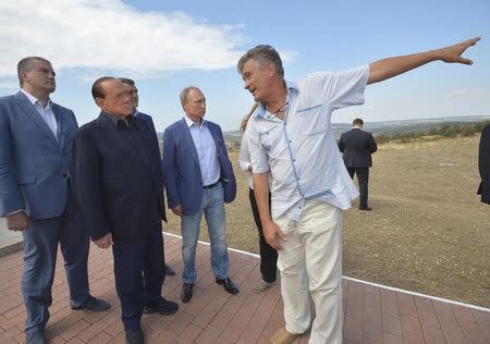 Russian President Vladimir Putin (4th L), former Italian prime minister Silvio Berlusconi (2nd L), Governor of Sevastopol Sergei Menyailo (3rd L) and Crimean Prime Minister Sergei Aksyonov (L) listen to explanations as they visit a monument to soldiers of the Kingdom of Sardinia, killed during the Crimean War, near Mount Gasfort in Crimea, September 11, 2015. REUTERS/Alexei Druzhinin/RIA Novosti/Kremlin