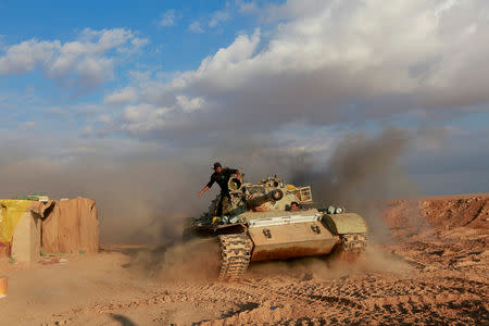 Popular Mobilisation Forces (PMF) fighters ride in a tank near the Iraqi-Syrian border in al-Qaim, Iraq. Iraq November 26, 2018. REUTERS/Alaa al-Marjani/Files