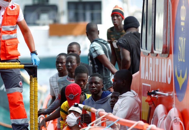 Migrants wait to disembark from a Spanish coast guard vessel in the port of Arguineguin on the island of Gran Canaria