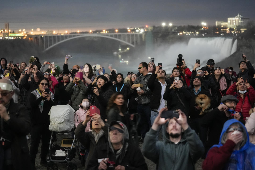 People gather to watch the total solar eclipse from Niagara Falls, Ontario, Monday, April 8, 2024. (AP Photo/Matt Rourke)