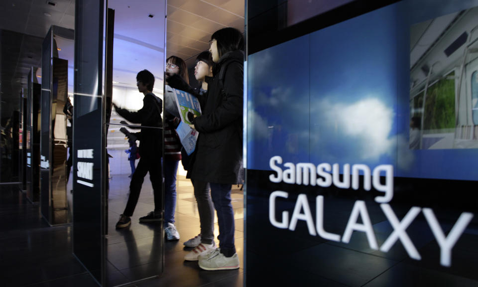 Students look at the huge screen of Samsung Electronics Co. at a showroom of its headquarters in Seoul, South Korea, Friday, April 6, 2012. Samsung Electronics is expecting a record operating profit of $5.1 billion for the first quarter of this year. The Suwon, South Korea-based company said Friday the result would be a 97 percent rise from its operating profit a year earlier. (AP Photo/Lee Jin-man)