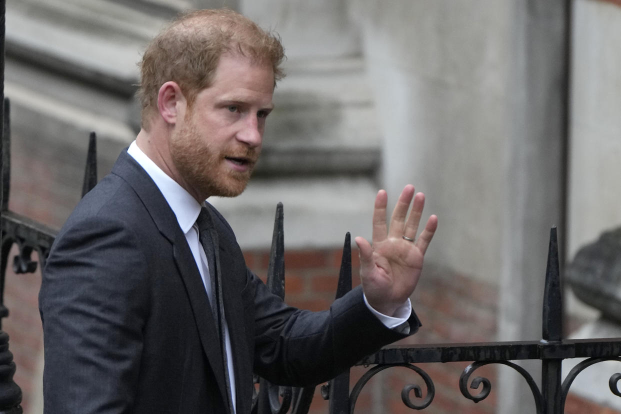 Britain's Prince Harry waves to the media as he arrives at the Royal Courts Of Justice in London, Tuesday, March 28, 2023. Prince Harry is in a London court on Tuesday as the lawyer for a group of British tabloids prepared to ask a judge to toss out lawsuits by the prince, Elton John and several other celebrities who allege phone tapping and other invasions of privacy.(AP Photo/Alastair Grant)