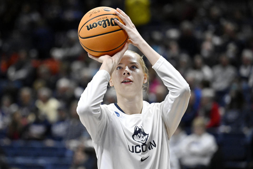 UConn's Dorka Juhasz (14) warms up before a first-round college basketball game against Vermont in the NCAA Tournament in Storrs, Conn., March 18, 2023. Juhasz is among players headed to the draft. Even the handful of players selected in the upcoming WNBA draft will find it difficult to continue their pro careers. (AP Photo/Jessica Hill)