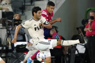 Los Angeles FC forward Carlos Vela, left, stops a shot from Dallas FC midfielder Bryan Acosta during the first half of an MLS soccer match Wednesday, June 23, 2021, in Los Angeles. (AP Photo/Marcio Jose Sanchez)