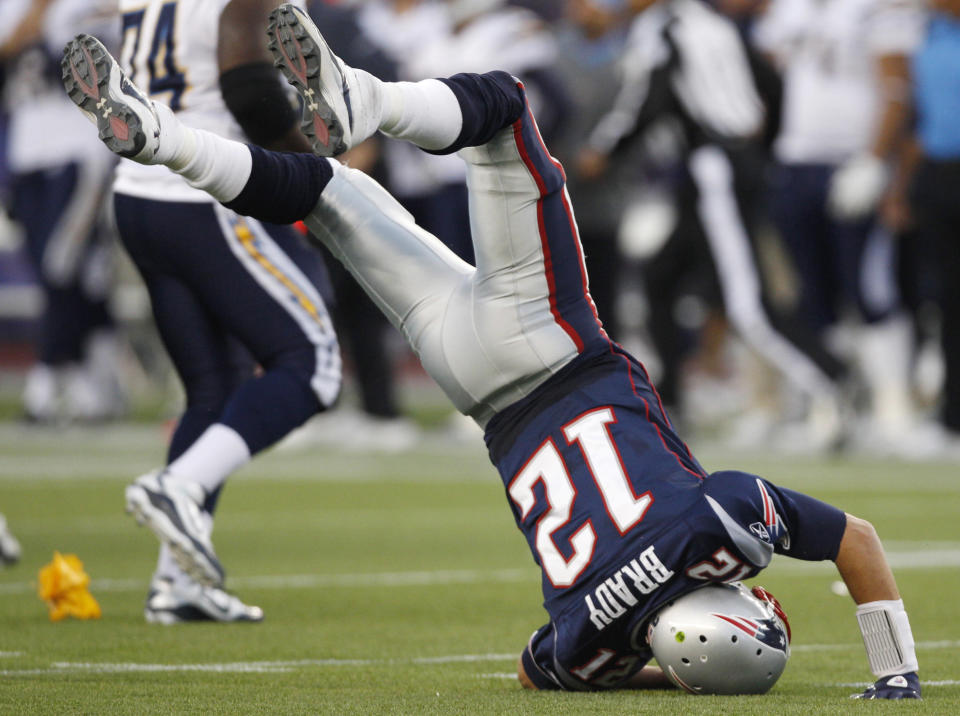 New England Patriots quarterback Tom Brady (12) flips over on his head after he was hit hard by San Diego Chargers defensive tackle Cam Thomas, not seen, in the second half of an NFL football game in Foxborough, Mass., Sunday, Sept. 18, 2011. (AP Photo/Charles Krupa)