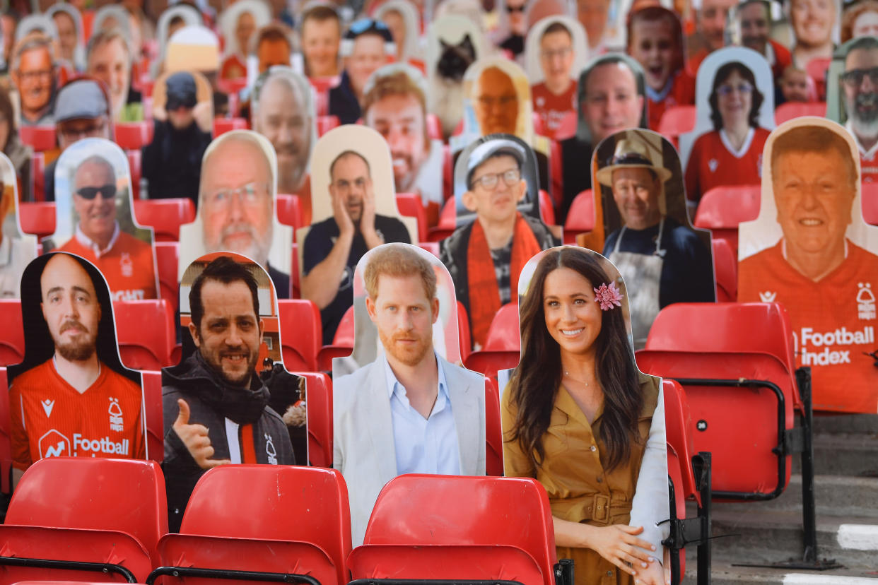 NOTTINGHAM, ENGLAND - JUNE 28: Harry and Meghan the Duke and Duchess of Sussex look out amongst the cardboard fans profile pictures in the main stand ahead of the Sky Bet Championship match between Nottingham Forest and Huddersfield Town at City Ground on June 28, 2020 in Nottingham, England. (Photo by Laurence Griffiths/Getty Images)