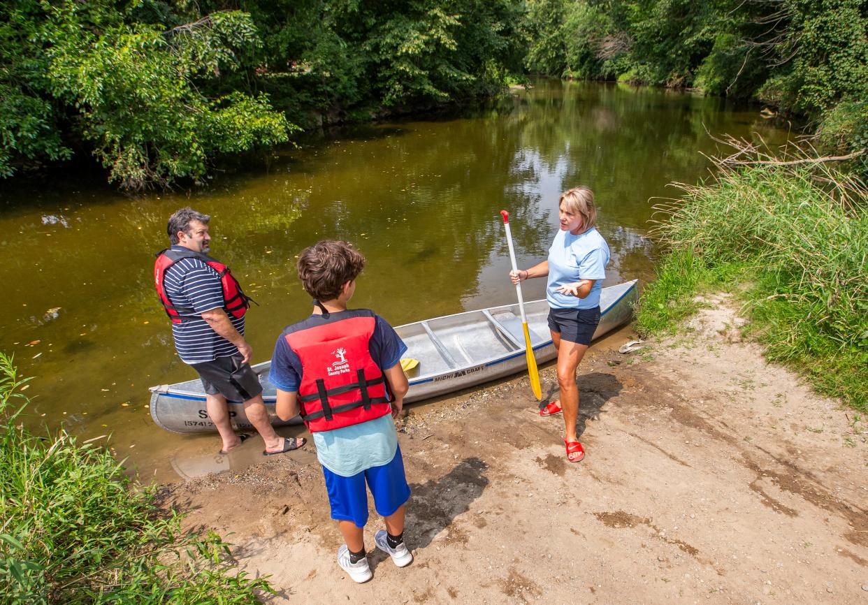 Jamie Hartzke gives pointers to Terry Fairres, left, and his grandson, Kaden Gottman, 13, before they launch a rented canoe in August 2021 at Ferrettie-Baugo Creek County Park in Osceola.