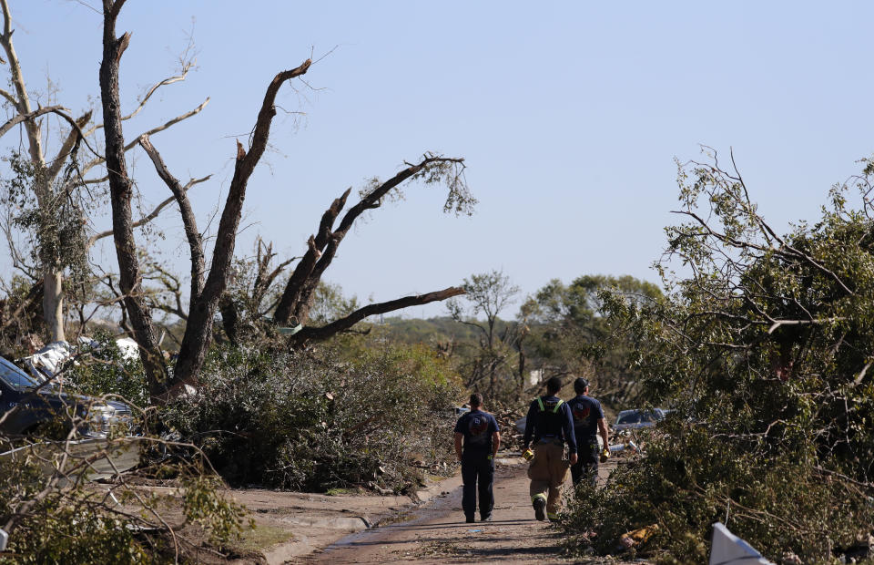 Firefighters walk in a neighborhood damaged by a tornado in Dallas, Tuesday, Oct. 22, 2019. The National Weather Service says nine tornadoes struck the Dallas area during Sunday's stretch of severe storms in Texas. (AP Photo/LM Otero)