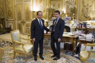 French newly appointed Prime minister Manuel Valls, right, stands with French President Francois Hollande before the first cabinet meeting of his government at the Elysee Palace in Paris, Friday, April 4, 2014. Hollande shook up the government this week after his Socialist Party suffered an electoral defeat in nationwide municipal elections. Among two new faces in the Cabinet is Segolene Royal, a longtime politician and mother of Hollande's children, as environment and energy minister. (AP Photo/Fred Dufour, Pool)