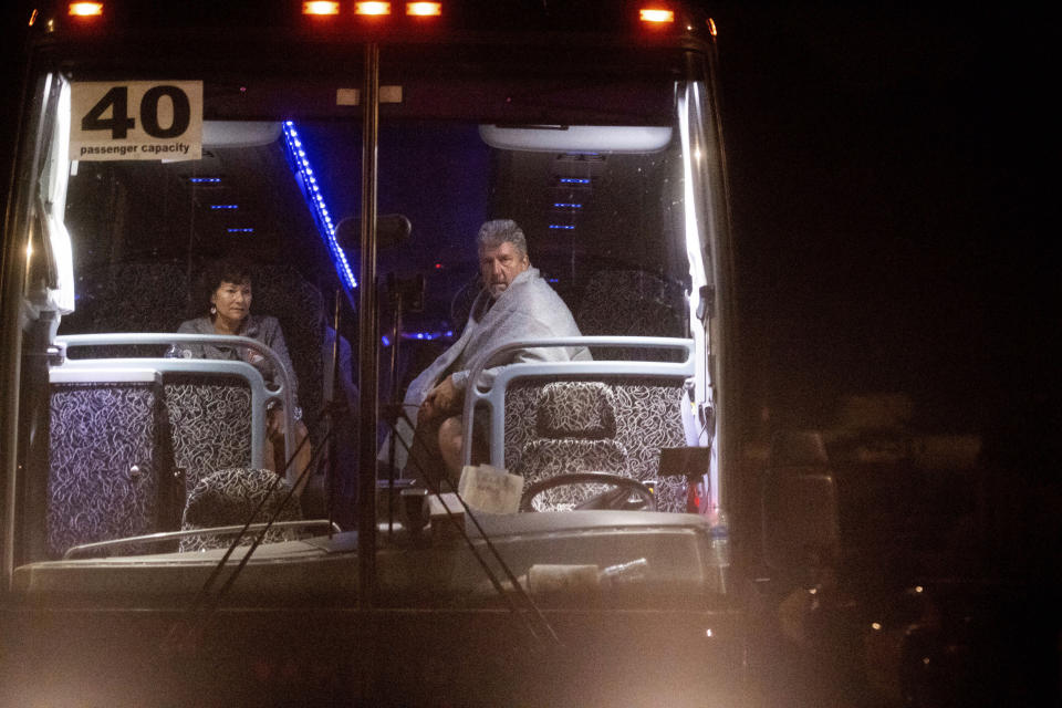 Edward and Jane Jacobucci rest on a bus after leaving Christmas Hill Park following a deadly shooting at the Gilroy Garlic Festival, in Gilroy, Calif., on Sunday, July 28, 2019. The couple, who were manning a booth selling garlic graters, said they took shelter behind their stand as a gunman opened fire in from of them. (AP Photo/Noah Berger)