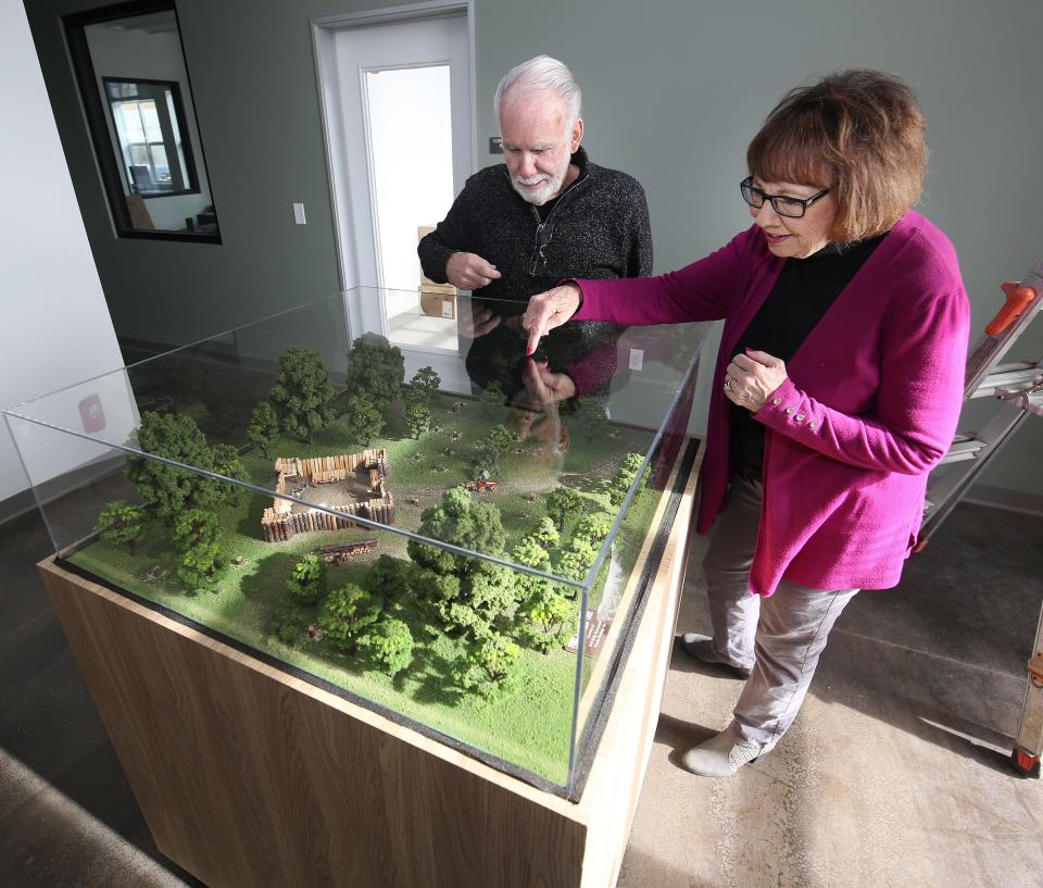 Rick and Susan Mangini are shown by a newly created diorama at the Fort Visalia Heritage Room in Visalia, Calif., Monday, Dec. 4, 2023, which was the old lumberyard and the original site of Fort Visalia, the first European settlement that started the town.