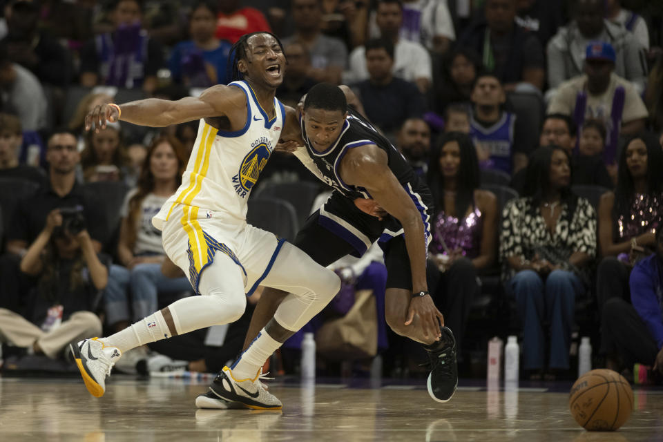 Sacramento Kings guard De'Aaron Fox (5) strips the ball away from Golden State Warriors forward Jonathan Kuminga (00) in the second half of a preseason NBA basketball game in Sacramento, Calif., Sunday, Oct. 15, 2023. (AP Photo/José Luis Villegas)