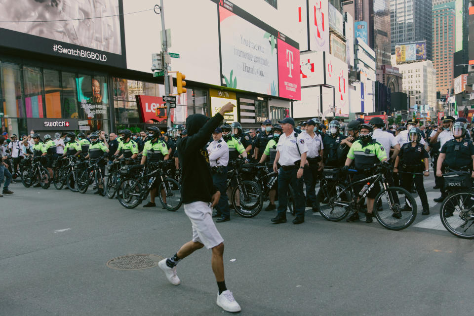 A protester walks by officers in Times Square on May 30. | Mark Clennon