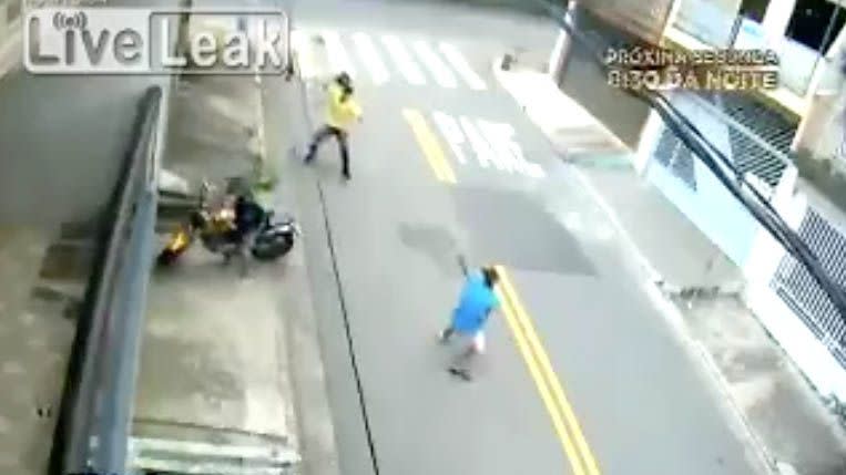The bike owner throws his helmet at the assailant, who has a gun pointed back at him. Photo: LiveLeak