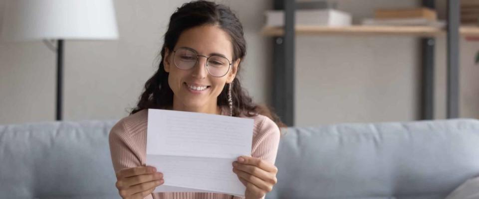 Smiling female student reading paper