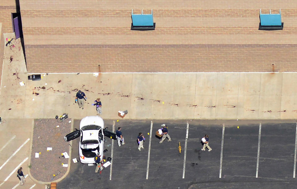 Police examine the car of James Eagen Holmes behind the theater where a gunman opened fire on moviegoers in Aurora, Colo. July 20, 2012. A total of 71 people were shot and 12 people were killed in the Denver-area movie theater, the local police chief said. The suspect, identified by police as James Eagan Holmes, 24, also booby-trapped his Aurora apartment with sophisticated explosives, creating a hazard for law-enforcement and bomb squad officers who swarmed to the scene. | John Wark—Reuters