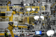 Articulated robots move inside the Hanwha Qcells Solar plant, Monday, Oct. 16, 2023, in Dalton, Ga. The Korean company is opening what it says is the first solar panel factory to begin production in the U.S. since the passage of President Joe Biden’s signature climate legislation. (AP Photo/Mike Stewart)