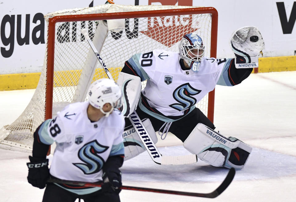 Seattle Kraken goaltender Chris Driedger (60) makes a glove save against the Florida Panthers during the first period of an NHL hockey game Saturday, Nov. 27, 2021, in Sunrise, Fla. (AP Photo/Jim Rassol)