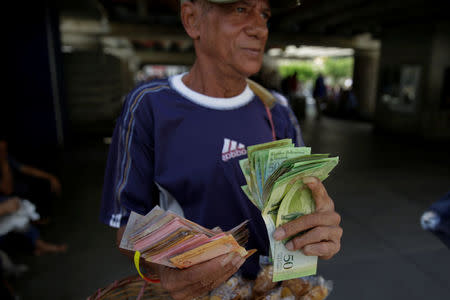 A street vendor counts bolivar notes near Venezuela's Central Bank in Caracas, Venezuela December 16, 2016. REUTERS/Marco Bello