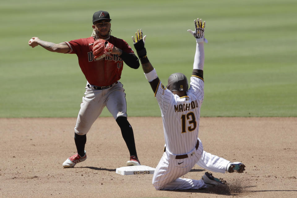 Arizona Diamondbacks second baseman Ketel Marte throws to first to complete the double play as San Diego Padres' Manny Machado (13) slides into second after being forced during the fourth inning of a baseball game Monday, July 27, 2020, in San Diego. Tommy Pham was out at first. (AP Photo/Gregory Bull)