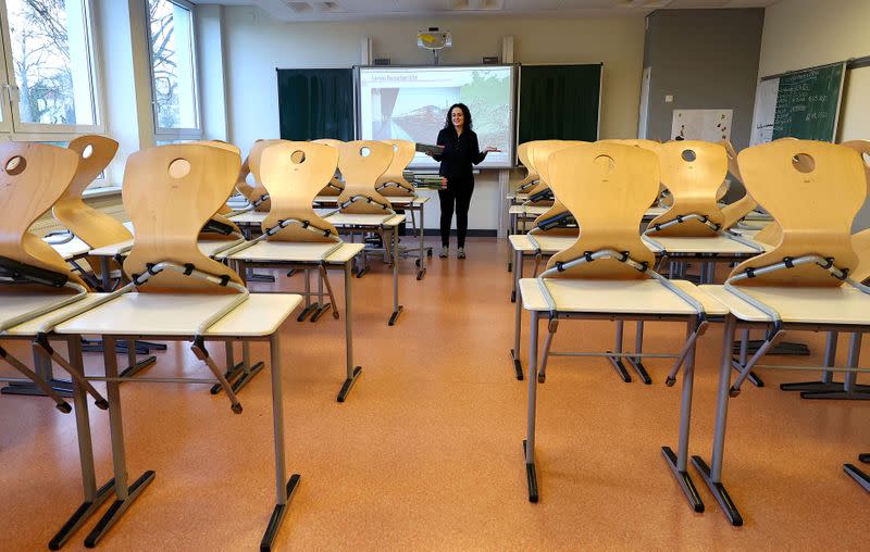 FILE PHOTO: Geography teacher Dinar Pamukci stands in front of the multimedia board at Hesse's largest high school, Karl-Rehbein-Schule, in Hanau, after authorities decided to close schools in most of Germany's federal states due to the coronavirus disease